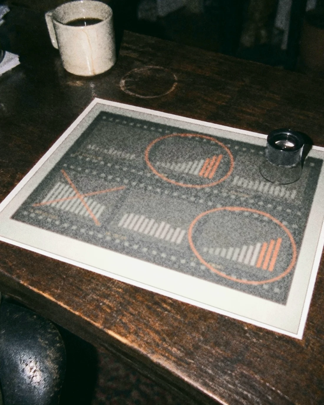 A hand lifting an index card from a wooden drawer of customer records on an office desk at night